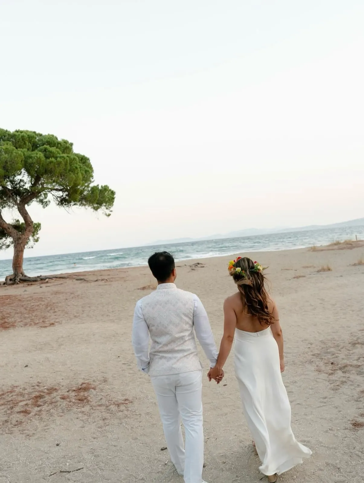 A couple walking hand in hand along the shoreline